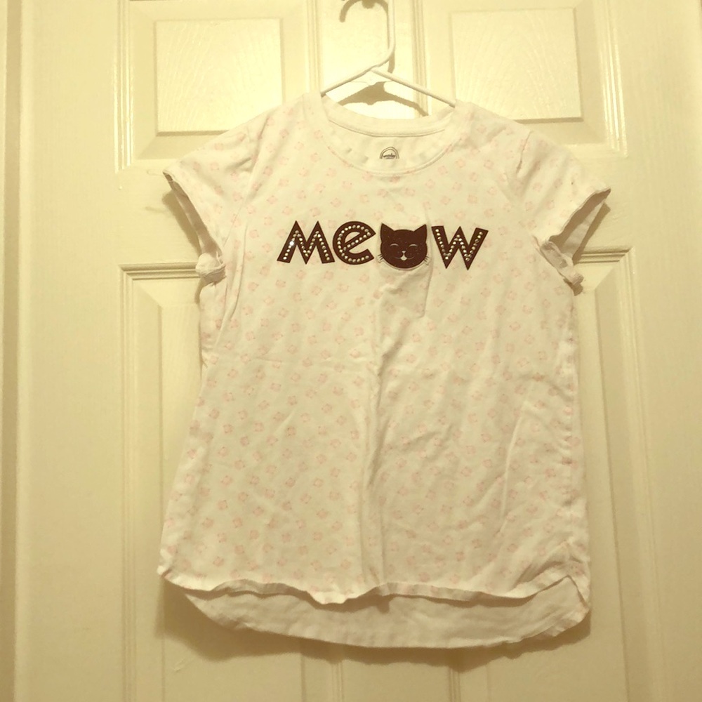 A cat shirt that says meow with cats all over it